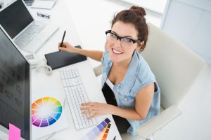 Smiling designer using computer and digitizer